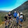 A guide speaking to 4 Guests while standing on a hillside during a hike